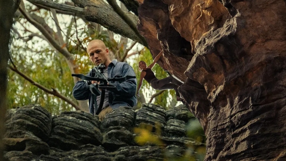 Kaalgeschoren Taron Egerton jaagt op blootvoetse Charlize Theron in trailer 'Apex'